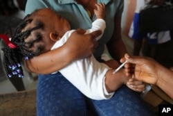 FILE - A health worker administers the malaria vaccine R21/Matrix-M to a child at the comprehensive Health Centre in Agudama-Epie, in Yenagoa, Nigeria, Dec. 9, 2024.