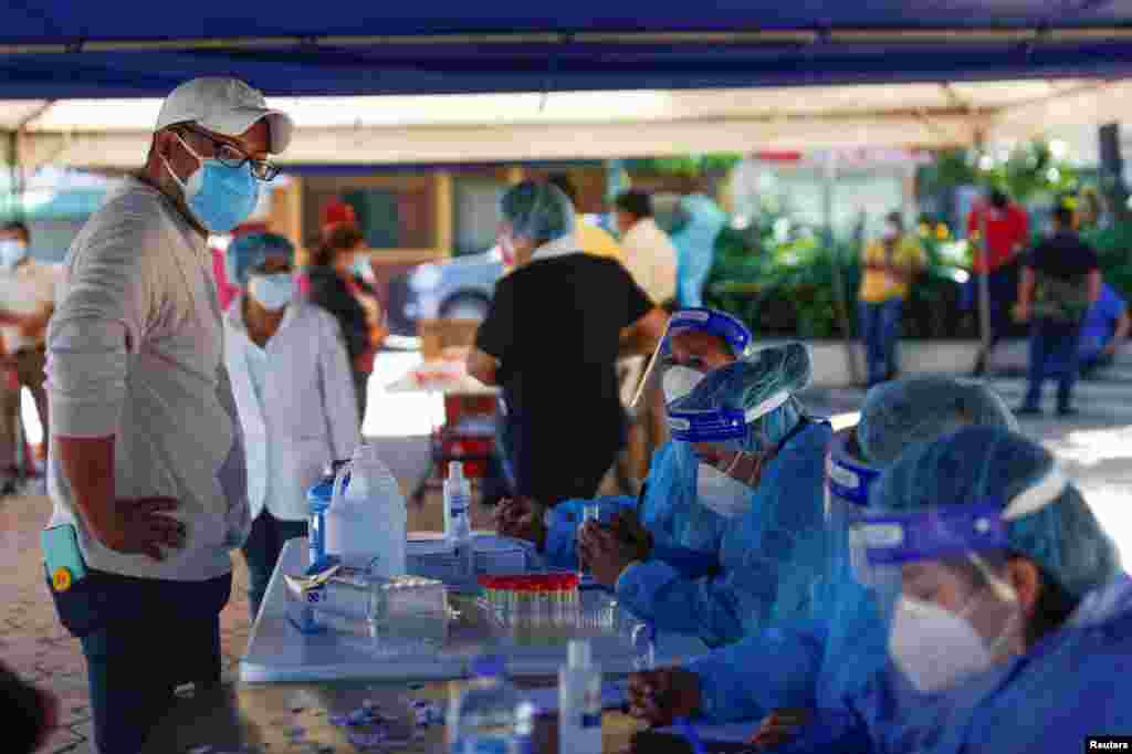 Pruebas de COVID-19 se est&#225;n administrando en todo el mundo, a medida que los casos contin&#250;an aumentando. En Antiguo Cuscatlan, El Salvador, el gobierno instal&#243; cabinas de pruebas en un parque local. 