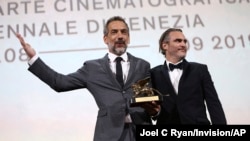 Director Todd Phillips, left, holds the Golden Lion for Best Film for "Joker," joined by lead actor Joaquin Phoenix at the 76th edition of the Venice Film Festival, Venice, Sept. 7, 2019.