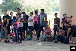 Migrants who crossed into the U.S. from Mexico wait to be processed by U.S. Border Patrol agents, Thursday, Sept. 21, 2023, in Eagle Pass, Texas. (AP Photo/Eric Gay)