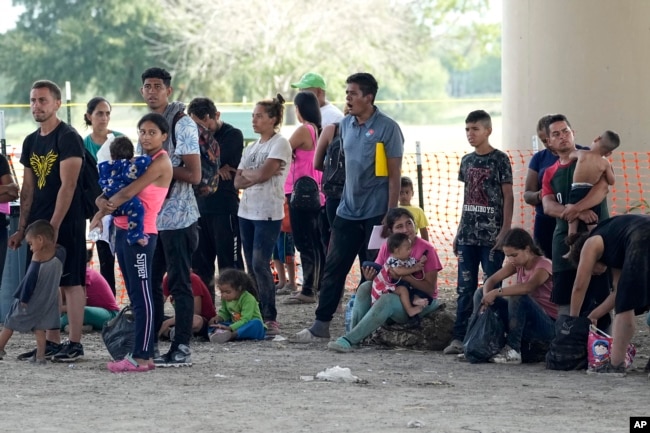 Migrants who crossed into the U.S. from Mexico wait to be processed by U.S. Border Patrol agents, Thursday, Sept. 21, 2023, in Eagle Pass, Texas. (AP Photo/Eric Gay)