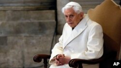 পোপ ইমেরিটাস ষোড়শ বেনেডিক্টকে সেন্ট পিটার্স ব্যাসিলিকায় বসে থাকতে দেখা যাচ্ছে। সে সময় তিনি পবিত্র বছরের সূচনা অনুষ্ঠানে যোগ দিচ্ছেন। ৮ ডিসেম্বর, ২০১৫। ফাইল ছবি।