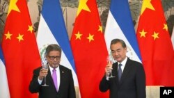 El Salvador's Foreign Minister Carlos Castaneda and China's Foreign Minister Wang Yi celebrate a toast at a signing ceremony to mark the establishment of diplomatic relations between El Salvador and China August 21, 2018. (AP Photo/Mark Schiefelbein)