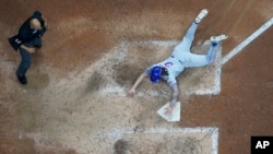 Jesse Winker, de los Mets de Nueva York, se desliza a salvo a casa tras un hit de Starling Marte durante la novena entrada del Juego 3 de un juego de comodines de béisbol de la Liga Nacional contra los Cerveceros de Milwaukee el jueves 3 de octubre de 2024, en Milwaukee.