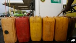 FILE- A man fills containers with diesel at a Nigeria National Petroleum Corporation petrol station in Abuja, Nigeria, May. 26, 2015.