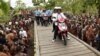 Presiden Joko Widodo dan Ibu Negara Iriana mengendarai sepeda motor listrik dalam kunjungan ke Agats, di Asmat, Provinsi Papua, 12 April 2018. (Antara Foto/Puspa Perwitasari/via REUTERS) 