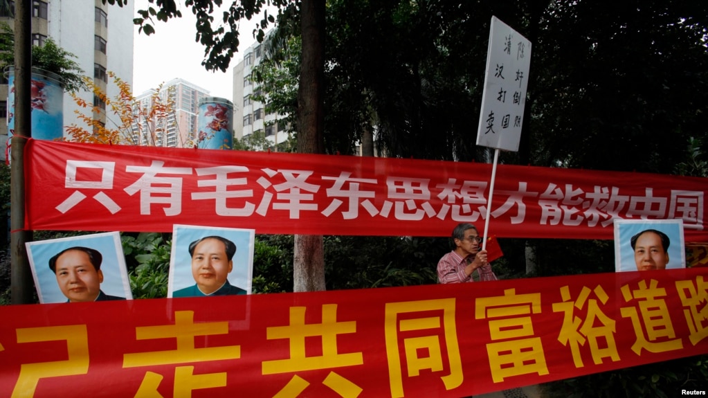 资料照：中国毛派人士手举毛泽东画像和标语横幅在广州南方周末报社外举行抗议集会。（2013年1月9日）(photo:VOA)