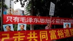资料照：中国毛派人士手举毛泽东画像和标语横幅在广州南方周末报社外举行抗议集会。（2013年1月9日）