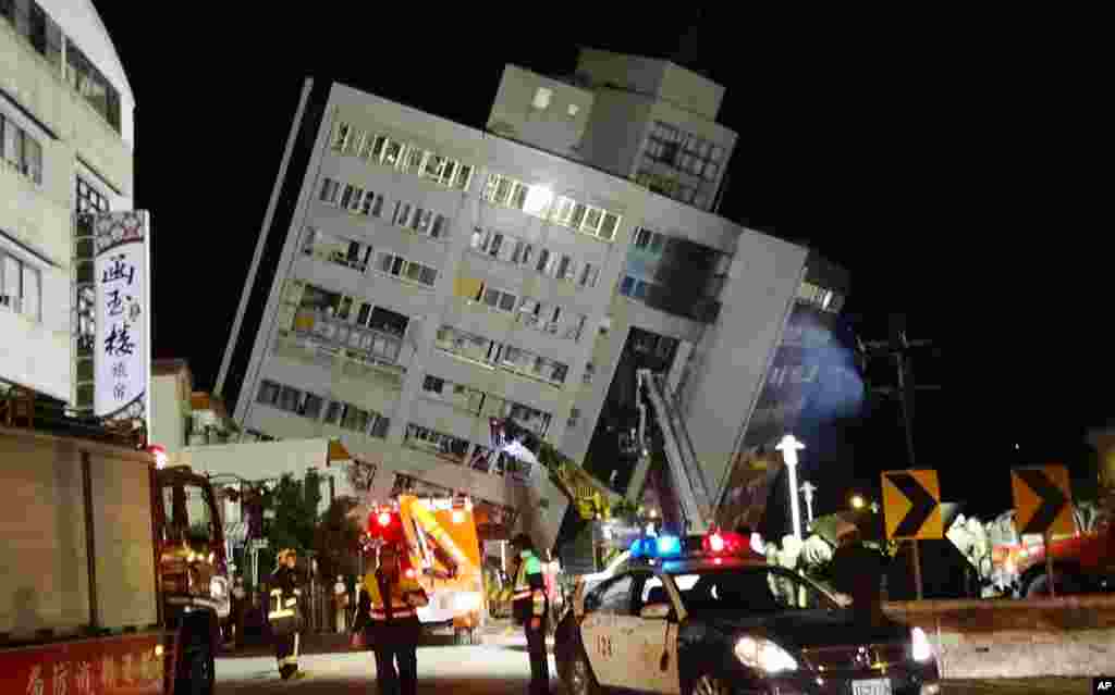 Rescuers are seen entering a building that collapsed onto its side from an early morning 6.4 magnitude earthquake in Hualien County, eastern Taiwan.