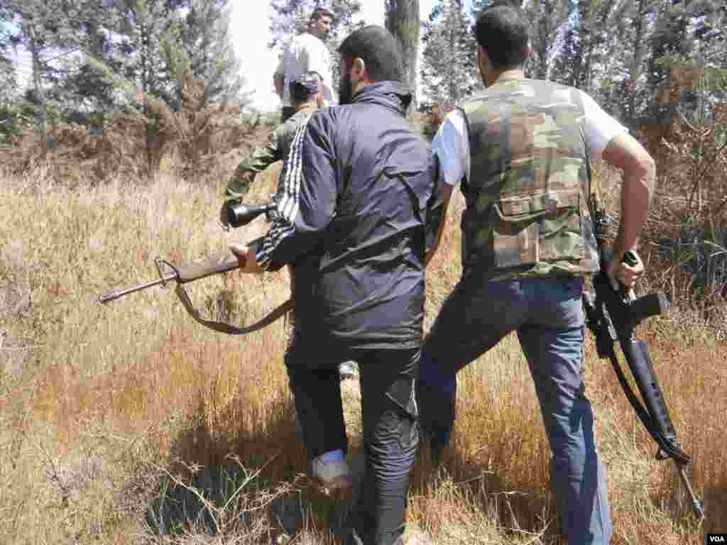 Members of the Free Syrian Army walk through Qusseer neighborhood in Homs, Syria, July 15, 2012. 