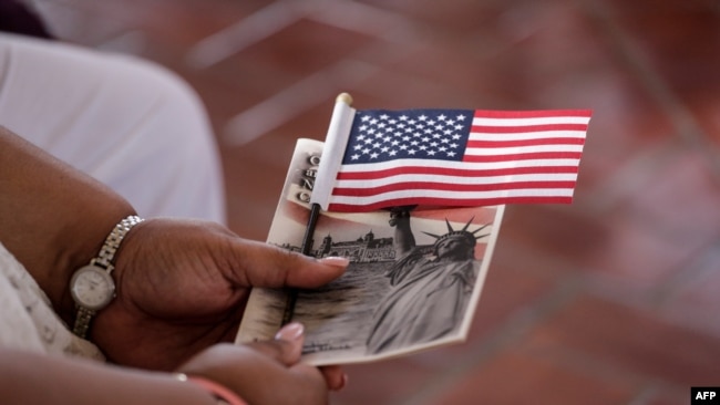 ARCHIVO - Una mujer sostiene una bandera estadounidense antes de convertirse en ciudadana ceremonia especial de naturalización en honor al Día de la Ciudadanía en Nueva York en septiembre de 2016.
