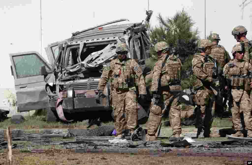 U.S. military forces inspect the site of a suicide attack near a U.S. military camp in Kabul, Afghanistan, Sept. 16, 2014.