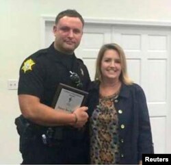 Richland County Sheriff's Department Officer Senior Deputy Ben Fields, left, is pictured with Lonnie B. Nelson Elementary School Principal Karen Beaman after receiving Culture of Excellence Award, in Columbia, S.C., Nov. 12, 2014.