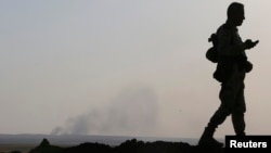 FILE - Smoke rises from a recent U.S. air strike on Islamic State militant positions in Khazir, on the edge of Mosul, Sept. 16, 2014. 