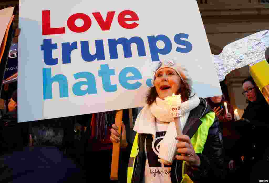 A woman holds a sign and a candle as she takes part in the women's rights event "Lights for Rights", a protest against the inauguration of Donald Trump as new U.S. president, in front of the Theatre Royal de la Monnaie in Brussels, Belgium, Jan. 20, 2017.