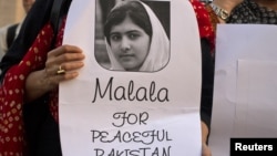 An activist from non-governmental organization Insani Haqooq Ittihad holds a picture of Malala Yousufzai during a demonstration in Islamabad, October 10, 2012. 