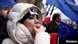 A woman whistles during an anti-government demonstration in front of the Constitutional Court in Warsaw, Poland, Dec. 12, 2015. 