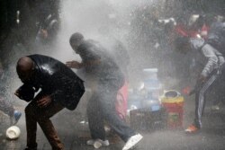 Police fire a water cannon at refugees evicted from a protest against xenophobia outside the U.N. High Commissioner for Refugees offices in Cape Town, South Africa, Oct. 30, 2019.