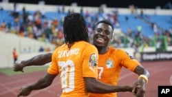 Serge Aurier, à droite, et Gervinho, à gauche, de la Côte-d'Ivoire, s’embrassent après la qualification de la sélection ivoirienne en quart de finale de la Coupe d'Afrique des Nations au détriment de l'Algérie qu’ils ont battue au stade de Malabo, Guinée équatoriale, 1er février 2015. (AP/ Dimanche Alamba)