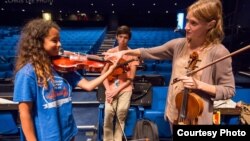 Carrie Dennis, Principal Viola with the Los Angeles Philharmonic, helps NYO-USA violist Mya Greene with her hand position. (Photo courtesy Chris Lee)