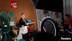 北京直播带货主播孙莎琪在直播中售卖二手奢侈品手提包。（2020年10月7日）