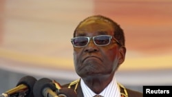 FILE - President Robert Mugabe waits to address crowds gathered for Zimbabwe's Heroes Day commemorations in Harare, Aug. 10, 2015.