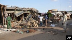 People gather at the site of a suicide bomb attack at a market in Maiduguri, Nigeria, June 22, 2015. 