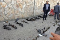FILE - Security personnel display weapons and equipment used in a suicide bomb attack and gunfight at the Interior Ministry, in Kabul, Afghanistan, May 30, 2018. The Islamic State group claimed responsibility for the attack.