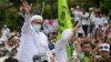 Rizieq Shihab (kiri), pemimpin Front Pembela Islam (FPI), menyapa para pendukungnya di markas FPI di Jakarta, setibanya dari Arab Saudi, 10 November 2020. (Foto oleh BAY ISMOYO/ AFP)