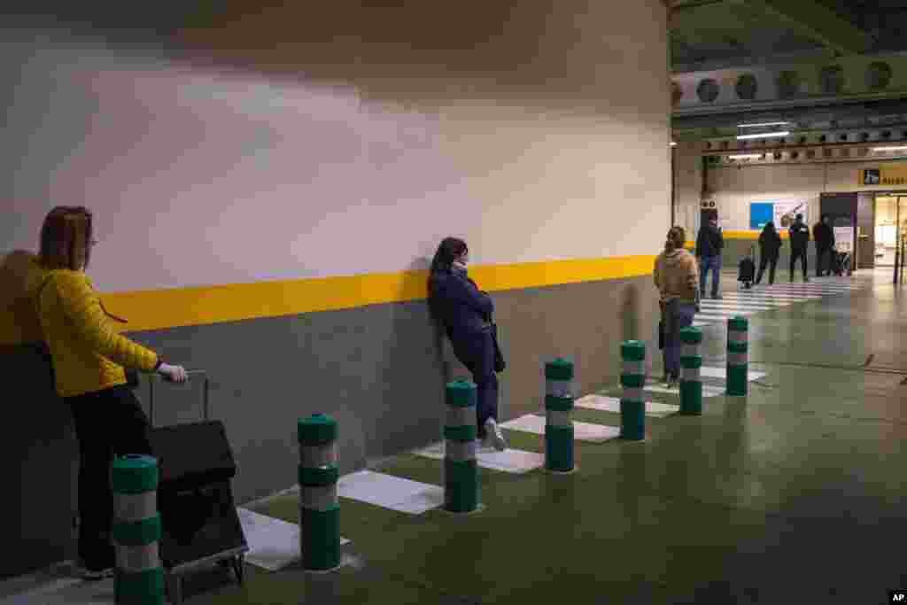 La gente hace cola para entrar en una tienda a comprar suministros en Barcelona, ​​España.