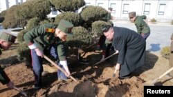 김정은 북한 국무위원장이 지난해 3월 '식수절'을 맞아 만경대혁명학원에서 학생들과 나무를 심고 있다.