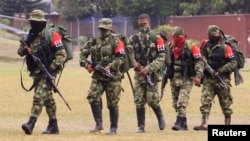 FILE - Defected members of Colombian guerrilla group ELN walk to a military base to surrender and handover their weapons, July 16, 2013. 