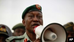 Brig. Gen. Chris Olukolade speaks to people at a demonstration calling on the government to rescue the kidnapped school girls from the Chibok government secondary school, outside the defense headquarters, in Abuja, May 6, 2014.