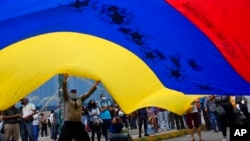 Partidarios de Tomás Guanipa, candidato a alcalde de la Mesa de Unidad Democrática (MUD) por el municipio Libertador, ondean una bandera venezolana en un mitin el primer día de la campaña 2021, en Caracas, Venezuela, el jueves 28 de octubre de 2021.