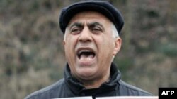 A man holds up photos during a protest against the execution of the government critics Jafar Kazemi and Mohammad Ali Hajaghaei who were killed in Iran at the Iran Embassy in the northern German city of Hamburg on January 24, 2011.