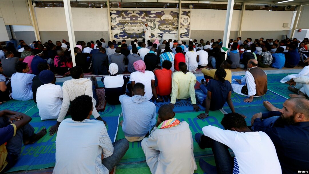 FILE - Migrants attend prayers at a detention center in Tripoli, Libya, June 15, 2018.