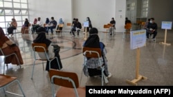 Sejumlah siswa duduk berjauhan untuk menjaga jarak sosial di tengah kekhawatiran penularan COVID-19, sebelum mengikuti ujian perguruan tinggi di Banda Aceh pada 5 Juli 2020. (Foto: AFP/Chaideer Mahyuddin)