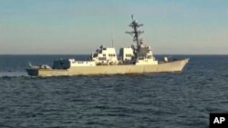 El destructor estadounidense USS Chafee es visto desde el destructor ruso Almirante Tributs cerca de aguas territoriales rusas en el Mar de Japón el viernes, 15 de octubre del 2021