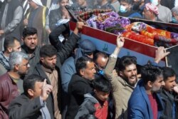 FILE - Iraqi mourners carry a coffin at the funeral of eight people killed a day earlier in attacks claimed by the Islamic State group, in the al-Bou Dor village of the Salaheddin governorate north of the capital, March 13, 2021.