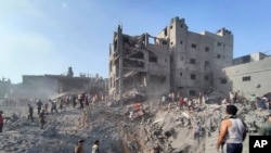Los palestinos inspeccionan los daños de los edificios destruidos por los ataques aéreos israelíes en el campo de refugiados de Jabaliya, en las afueras de la ciudad de Gaza, el martes 31 de octubre de 2023.