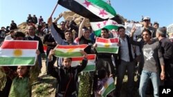 Kurdên Sûrîyê di xwepêşandanekê de, bi alên Kurdî û yên şoreşê xuya dibin