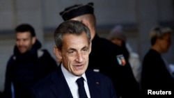 FILE - Former French President Nicolas Sarkozy arrives for his appeal trial on charges of corruption and influence peddling, at Paris courthouse, France, Dec. 15, 2022. 