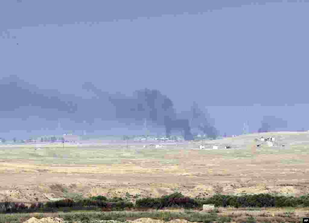Asap membubung dari lokasi kelompok militan Negara Islam (ISIS) menyusul serangan udara pasukan koalisi di Mosul, Irak (17/10). (AP/Khalid Mohammed)