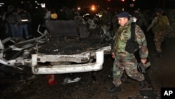 Lebanese army soliders stand guard near damages after a suicide bomber blew himself up in a passenger van in the Choueifat district in southern Beirut, Feb. 3, 2014 
