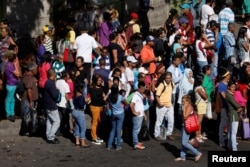 People try to find other modes of transportation after subway services were halted during a massive blackout in Caracas, Venezuela, Dec. 18, 2017.