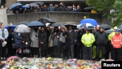 FILE - People near the scene of the recent attack observe a minute's silence in tribute to the victims of the attack at London Bridge and Borough Market, in central London, June 6, 2017.