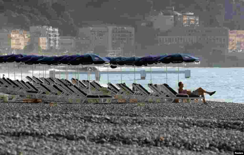 A man sunbathes on the beach during an unusually warm and sunny autumn day in Nice, France. 