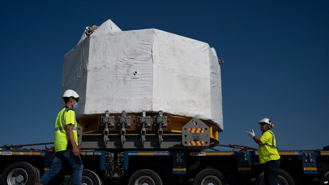 Workers secure a central solenoid magnet for the ITER project as it departs from Berre-l'Etang in southern France, Sept. 6, 2021.
