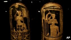 FILE: Ancient Egyptian shields made of wood covered with gesso and gold leaf displayed in a glass case during the exhibition of Tutankhamun's unseen treasures marking the 115th anniversary of the Egyptian museum in Cairo, Egypt, on Wed., Nov. 15, 2017. 