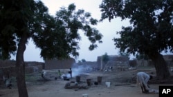 In this picture taken Saturday, July 21, 2012, children help prepare the evening meal in a courtyard in the remote village of Hawkantaki, Niger.